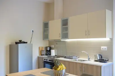 a kitchen with a refrigerator and a table with bananas at Alimos Modern Retreat, near the beach in Athens