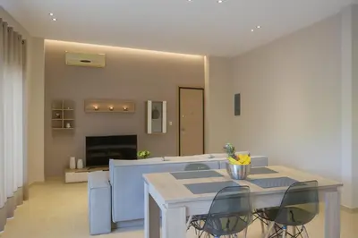 a dining table and chairs in a living room at Alimos Modern Retreat, near the beach in Athens