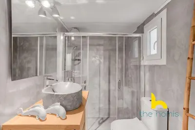 a bathroom with a tub and a shower and a sink at Lush island-style hideaway in lively Koukaki! in Athens