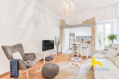 a living room with a couch and chairs and a kitchen at Lush island-style hideaway in lively Koukaki! in Athens