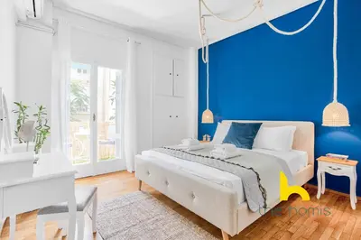 a blue bedroom with a bed and a blue wall at Lush island-style hideaway in lively Koukaki! in Athens