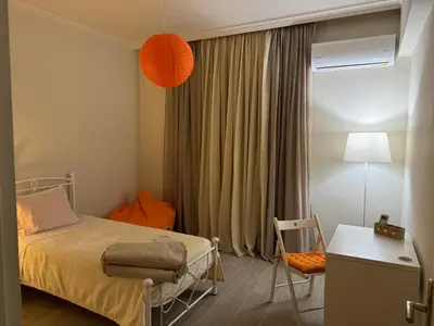 a bedroom with a bed and a table and a chair at Small Apartment in Markopoulo center in Markopoulo