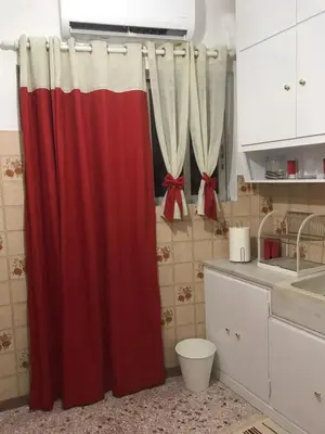 a red and white shower curtain in a kitchen at Small Apartment in Markopoulo center in Markopoulo