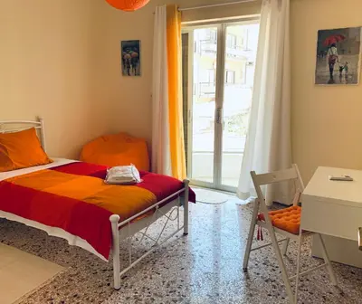 a bedroom with a bed and a window and a desk at Small Apartment in Markopoulo center in Markopoulo