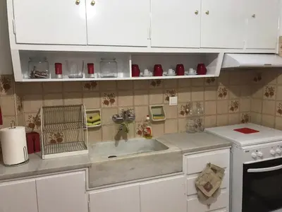 a kitchen with a sink and white cabinets at Small Apartment in Markopoulo center in Markopoulo