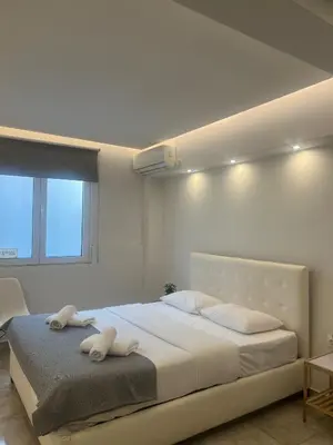 a bedroom with a large bed with two towels on it at Purple- Lux studio 2' from metro Petralona in Athens