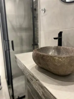 a bathroom with a stone sink on a counter at Purple- Lux studio 2' from metro Petralona in Athens