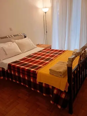 a bed with a plaid blanket on top of it at Archelaou Street Living in Athens