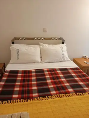 a bed with a plaid blanket on top of it at Archelaou Street Living in Athens