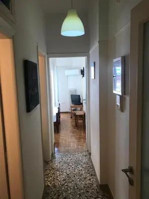 a hallway leading to a room with a desk and a light at Archelaou Street Living in Athens