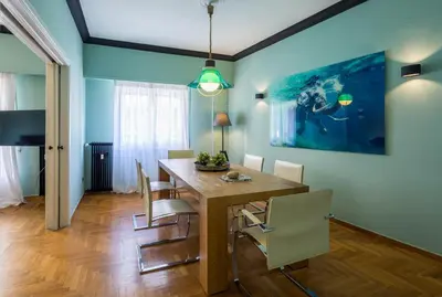 a dining room with a wooden table and chairs at Cathedrals square supreme residence in Athens