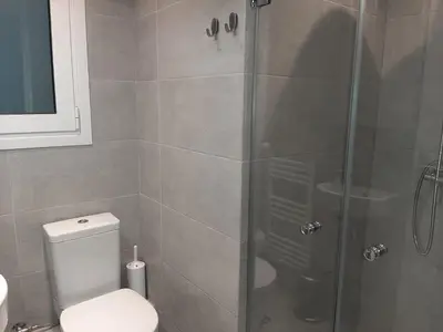 a bathroom with a toilet and a glass shower at Cathedrals square supreme residence in Athens