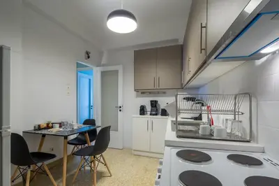 a kitchen with a table and chairs in a room at Cathedrals square supreme residence in Athens