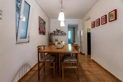 a dining room with a table and chairs at Comfortable garden Apt near Vouliagmeni beach in Athens