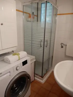 a bathroom with a washing machine and a sink at Comfortable garden Apt near Vouliagmeni beach in Athens