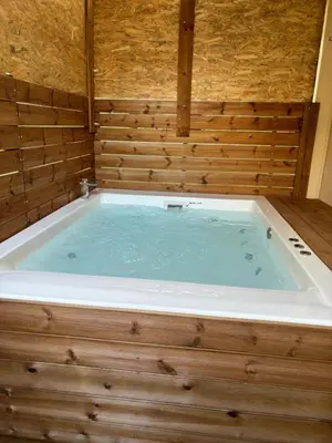a large jacuzzi tub in a wooden walled bath room at Jacuzzi studio close to athens airport!! in Pallíni
