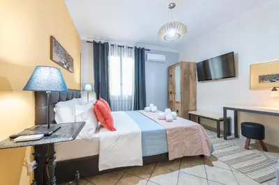 a bedroom with a bed and a desk and a television at Splash of Glam III 10 steps from Acropolis in Athens