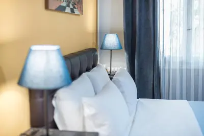 a hotel room with a bed with pillows and a lamp at Splash of Glam III 10 steps from Acropolis in Athens