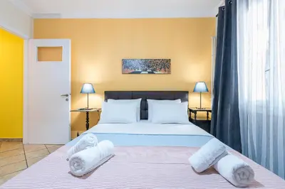 a bedroom with a large bed with towels on it at Splash of Glam III 10 steps from Acropolis in Athens