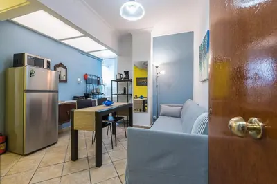 a kitchen and living room with a refrigerator and a table at Splash of Glam III 10 steps from Acropolis in Athens