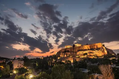 a castle on top of a mountain at sunset at Splash of Glam III 10 steps from Acropolis in Athens
