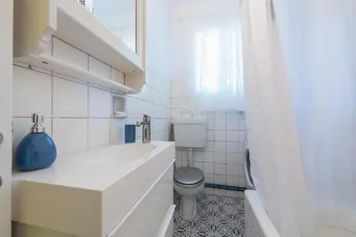 a white bathroom with a toilet and a sink at Splash of Glam III 10 steps from Acropolis in Athens