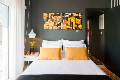 a bedroom with a bed with yellow pillows and a painting at Ma Maison No1 Penthouse, Acropolis view, 315 Mbps in Athens
