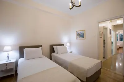 two beds in a room with white walls and wood floors at 