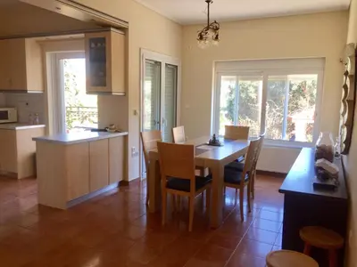 a kitchen and dining room with a table and chairs at Relaxing Villa with Swimming Pool and Garden in Áyios Yeóryios