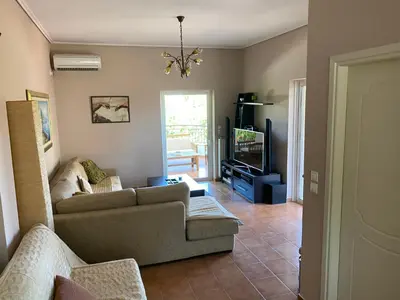 a living room with a couch and a tv at Relaxing Villa with Swimming Pool and Garden in Áyios Yeóryios