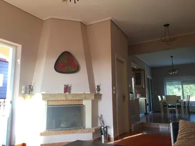 a living room with a fireplace and a tv at Relaxing Villa with Swimming Pool and Garden in Áyios Yeóryios