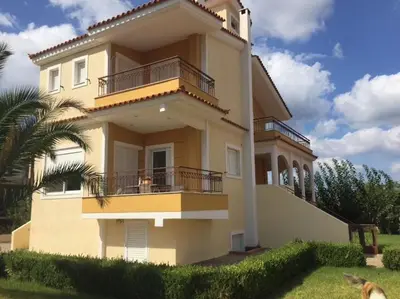 a large building with a balcony on the side of it at Relaxing Villa with Swimming Pool and Garden in Áyios Yeóryios