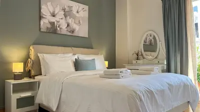 a bedroom with a white bed with towels on it at Central & Comfortable, 70m² Apt in Neos Kosmos in Athens