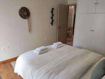 a white bed with two towels on top of it at Central & Comfortable, 70m² Apt in Neos Kosmos in Athens