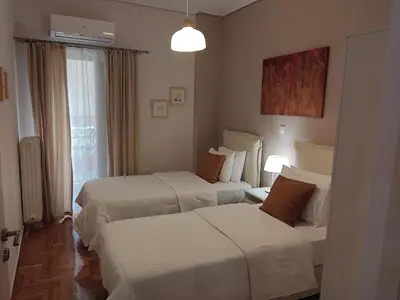 a hotel room with two beds and a window at Central & Comfortable, 70m² Apt in Neos Kosmos in Athens