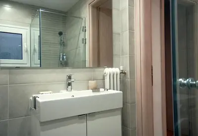 a bathroom with a white sink and a shower at Central & Comfortable, 70m² Apt in Neos Kosmos in Athens