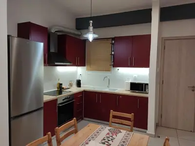 a kitchen with red cabinets and a stainless steel refrigerator at Central & Comfortable, 70m² Apt in Neos Kosmos in Athens