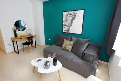 a living room with a gray couch and a blue wall at Old Town Hall Suites and Apartments in Athens