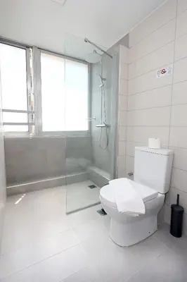 a bathroom with a toilet and a glass shower at Old Town Hall Suites and Apartments in Athens