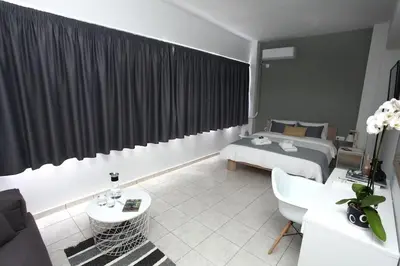 a hotel room with a bed and a living room at Old Town Hall Suites and Apartments in Athens