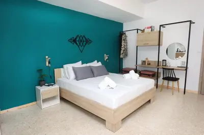 a bedroom with a large bed with a blue wall at Old Town Hall Suites and Apartments in Athens