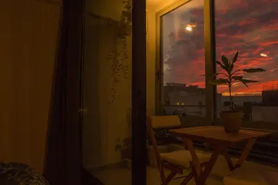 a room with a table and a window with a sunset at Mosaics aprtm in the historical center of Athens Ermou 18 in Athens