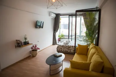 a living room with a yellow couch and a table at Mosaics aprtm in the historical center of Athens Ermou 18 in Athens