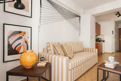 a living room with a couch and two tables at Boho House with Acropolis View! in Athens