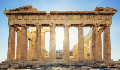 an ancient temple with columns in front of a building at Boho House with Acropolis View! in Athens