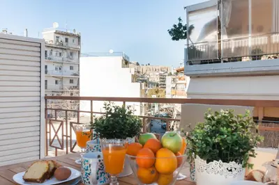 a bowl of fruit on a table on a balcony at Boho House with Acropolis View! in Athens