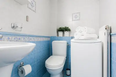 a blue and white bathroom with a toilet and a sink at Boho House with Acropolis View! in Athens