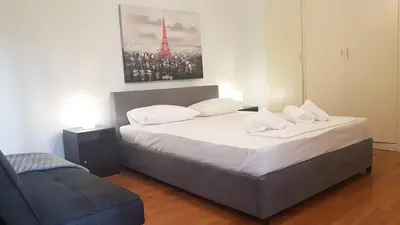 a bedroom with a bed and a chair in it at Violet Errathens Apartment - Athens Center, 7 BD, 3 BATH in Athens