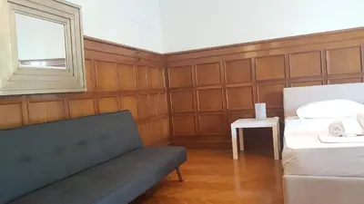 a room with a couch and a bed and a window at Violet Errathens Apartment - Athens Center, 7 BD, 3 BATH in Athens