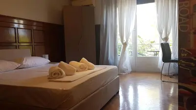 a bedroom with a bed with towels and a window at Violet Errathens Apartment - Athens Center, 7 BD, 3 BATH in Athens